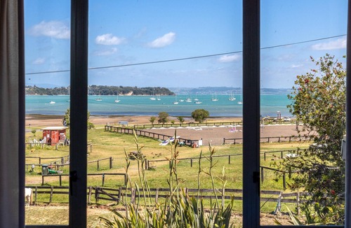Oneroa House | Tikirau Bay Views - Tikirau Bay Views is a wonderfully appointed family holiday home right next to the beach in Oneroa. With three bedrooms (2 x singles and 2 x queens) and a good sized family bathroom, this is the perfect location for a family group