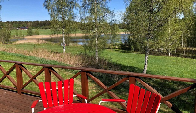 Nice red-white cottage by the lake with a boat